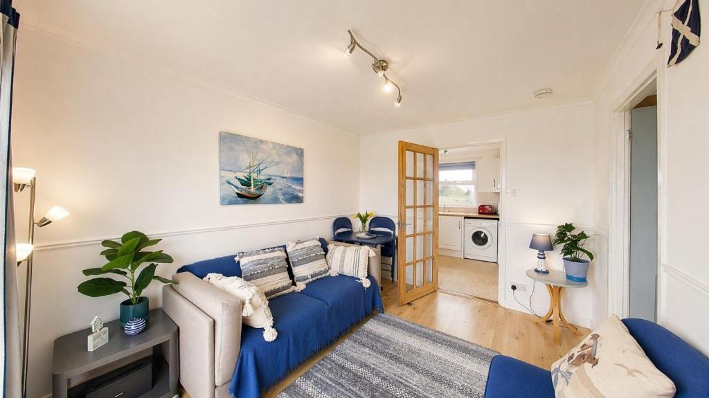 a living room with a blue couch in a room at F59 Trevone, Riviere Towans in Hayle