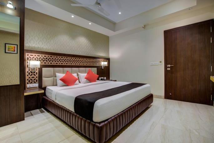 a bedroom with a large bed with red pillows at Hotel Radiant in Kolkata