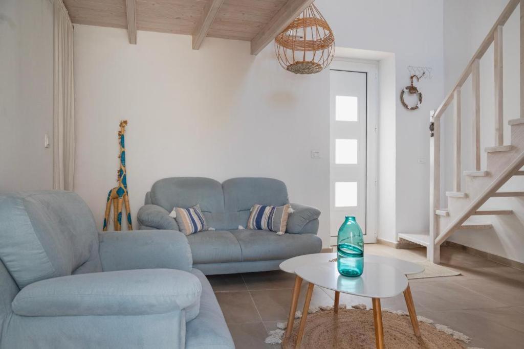 a living room with a blue couch and a table at Cosy 21 in Ialysos