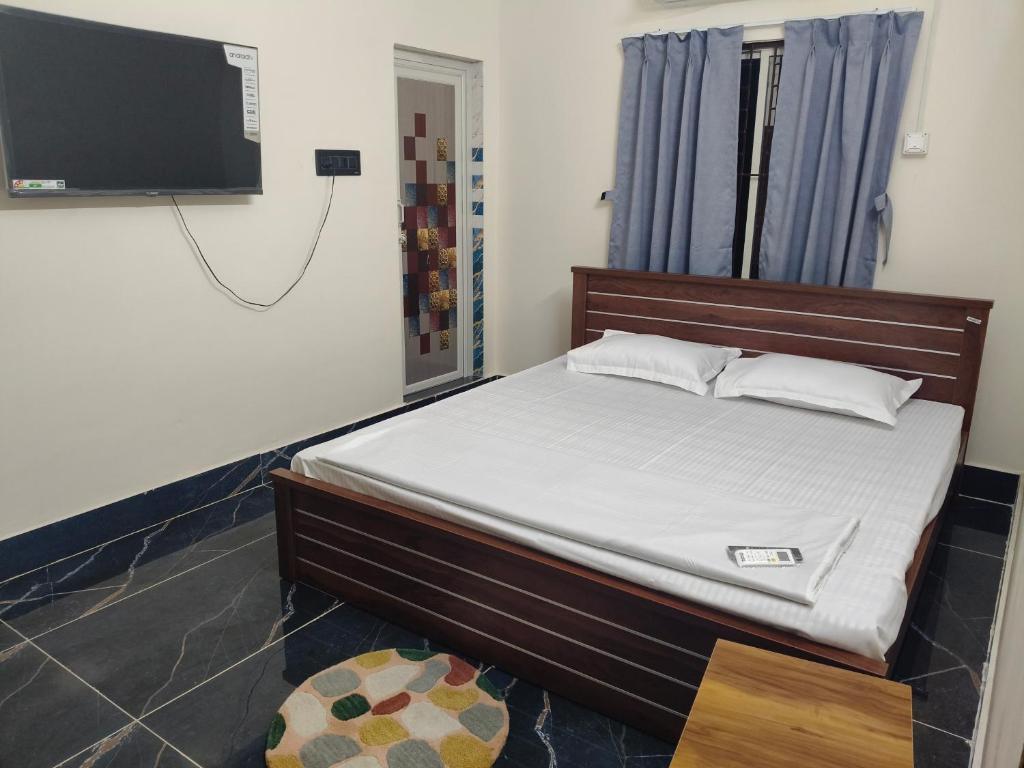 a bedroom with a bed and a flat screen tv at 101 Mahalaxmi Homes in Bhubaneshwar