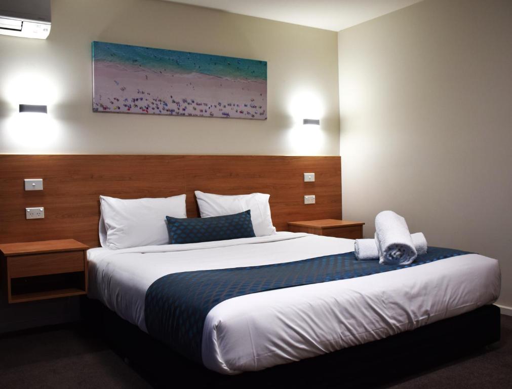 a bed in a hotel room with a large bed at Rainbow Motel Queanbeyan in Queanbeyan