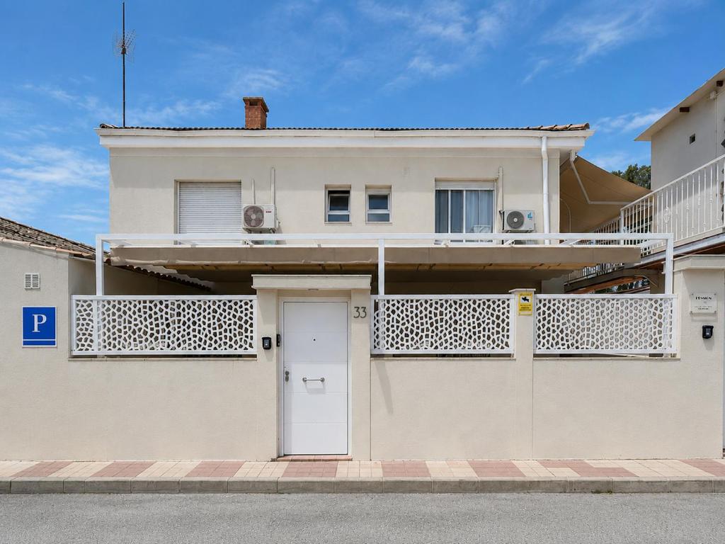 a white house with a white door and a balcony at PENSIÓN ISBEL in Málaga