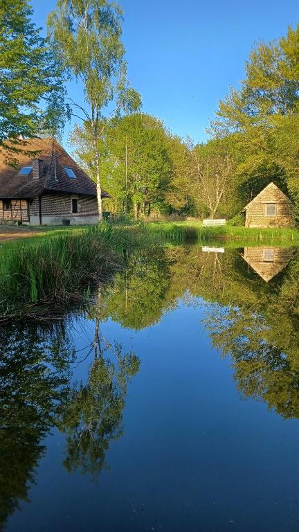 a reflection of a house in the water next to a lake at Le Gîte du Vauvril in Saint-Usuge