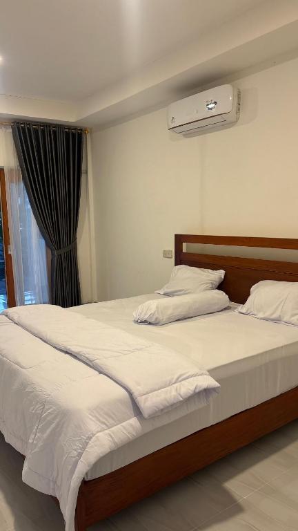 a bedroom with a bed with white sheets and a window at 3Z Homestay in Bayan