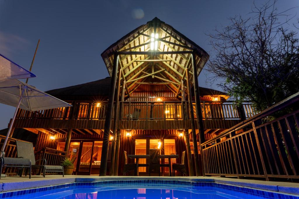 a large wooden house with a pool in front of it at Addo Nyala Guest Lodge in Paterson