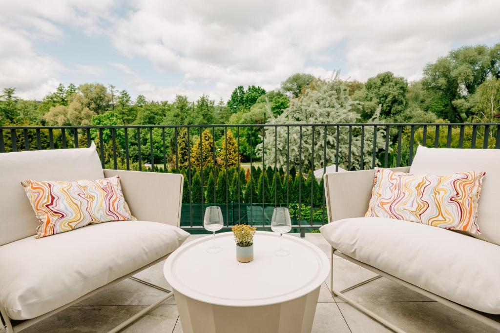 a patio with two white chairs and a table at Aria Apartments in Prievidza