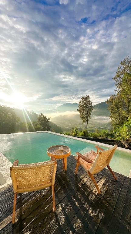 a deck with two chairs and a table and a pool at Alina pinggan in Gretek