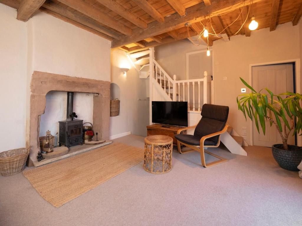 a living room with a chair and a fireplace at The Old Cookery Cottage & Free Parking in Goldsborough