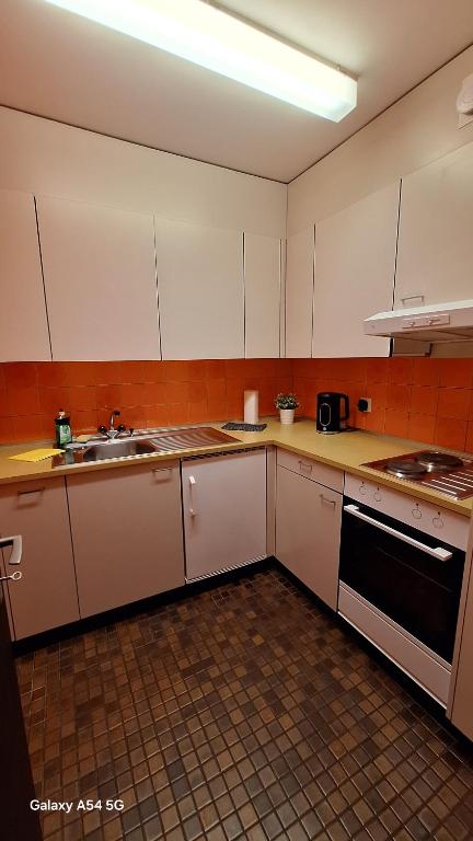 a kitchen with white cabinets and a sink at Messe-clarastrasse -Wohnung in Basel