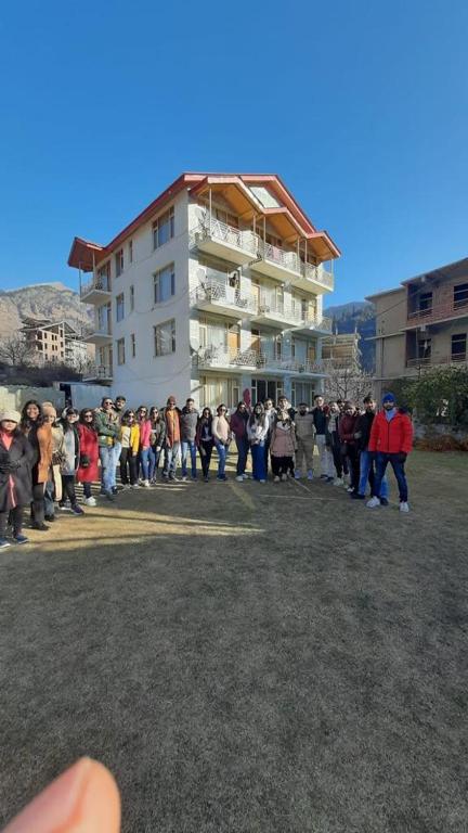 a group of people standing in front of a building at Snow Range Cottages in Manāli