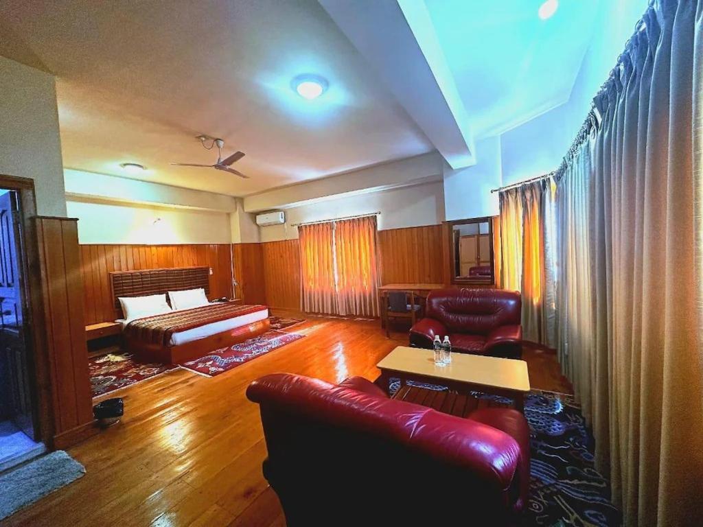 a living room with a couch and a bed at Hotel Pema Karpo in Yuwak