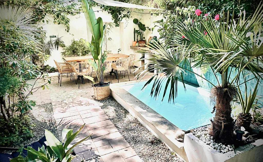 a garden with a swimming pool with plants and a table at Unique House with private swimming pool by the sea - AFRA GROUP in Sopot