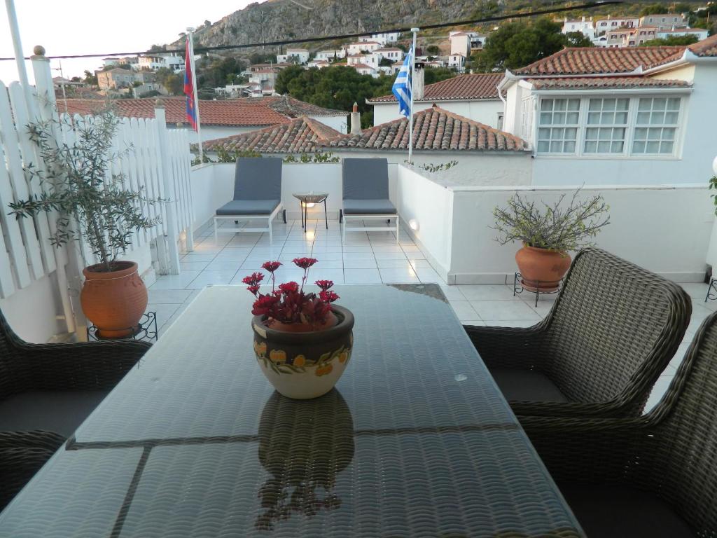 a table with a vase on it on a balcony at Perakis Apartments in Hydra
