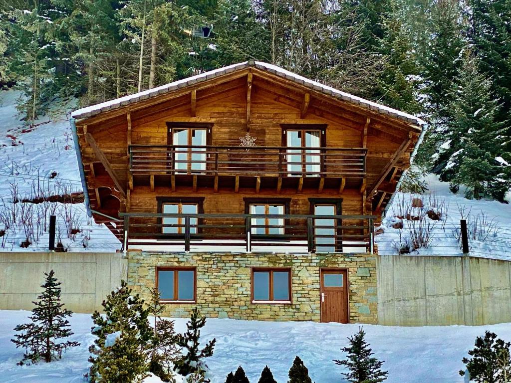 a log cabin in the snow with a porch at Chalet Le Jeuna in Morgins