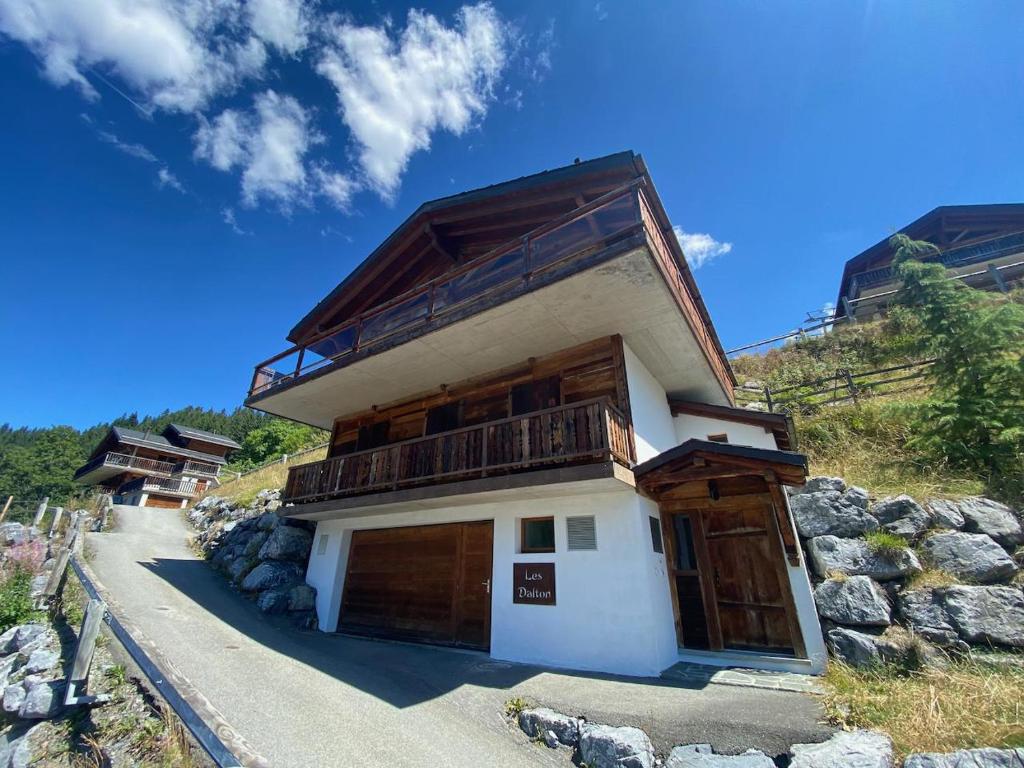 a building with wooden doors on a mountain at Chalet Les Dalton, Morgins in Morgins