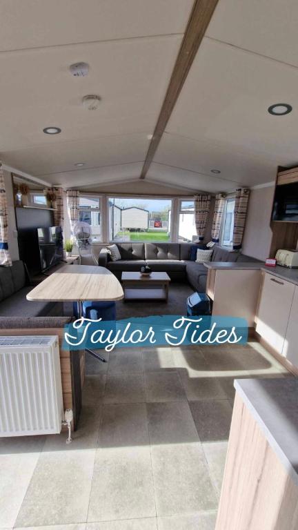 a living room with a couch and a table at Taylor Tides Caravan in Abergele