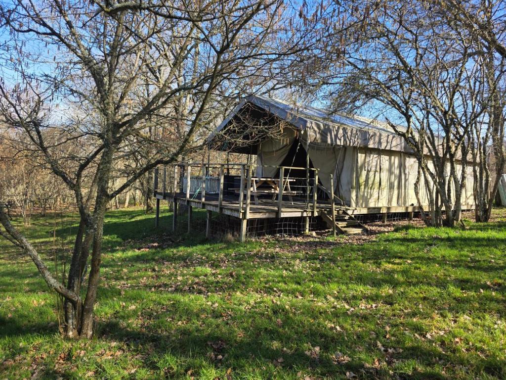 a building with a tent in a field with trees at La clés des champs in Loubeyrat