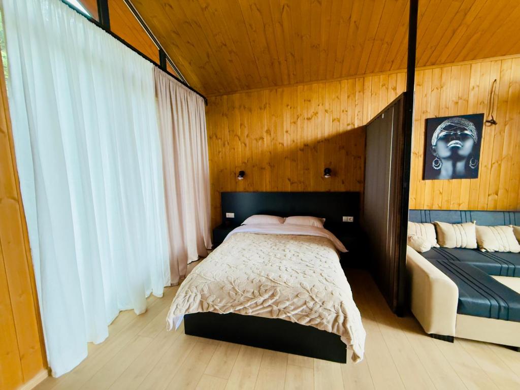a bedroom with a large bed and a window at Tianuli cottage in Kakhoianebi