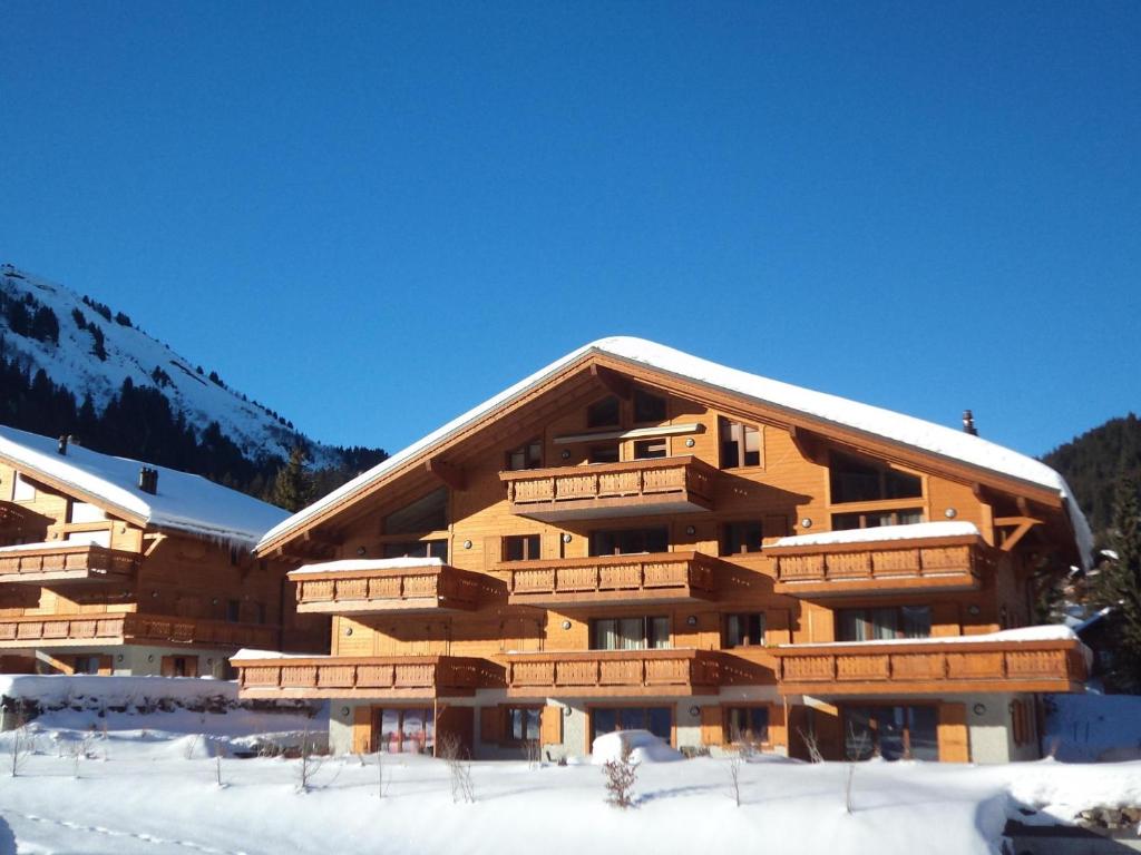 a large wooden building with snow on the ground at Edelweiss B31 in Morgins