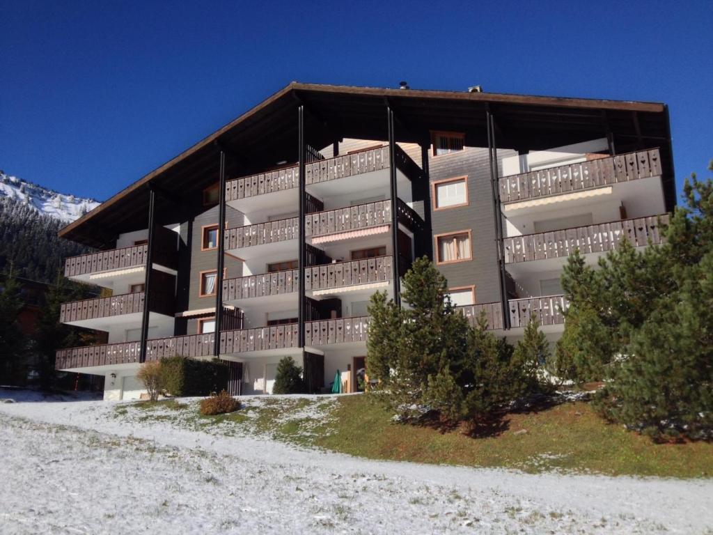 ein großes Wohnhaus mit Balkonen auf einem Hügel in der Unterkunft Pre Vert 44 in Morgins