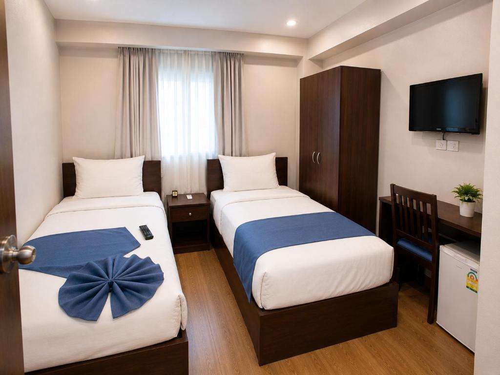 a hotel room with two beds and a television at Elysees Hotel I Tahrir Square in Cairo