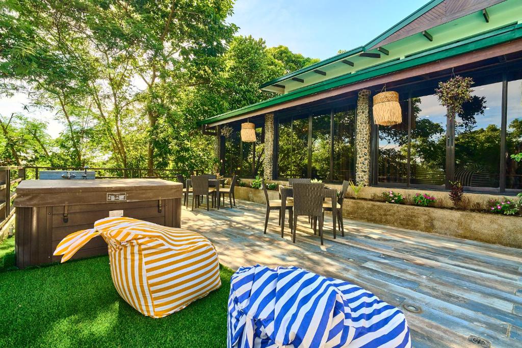 a backyard with a wooden deck with chairs and a grill at Cuatro Maya by Araw Residences in Nasugbu