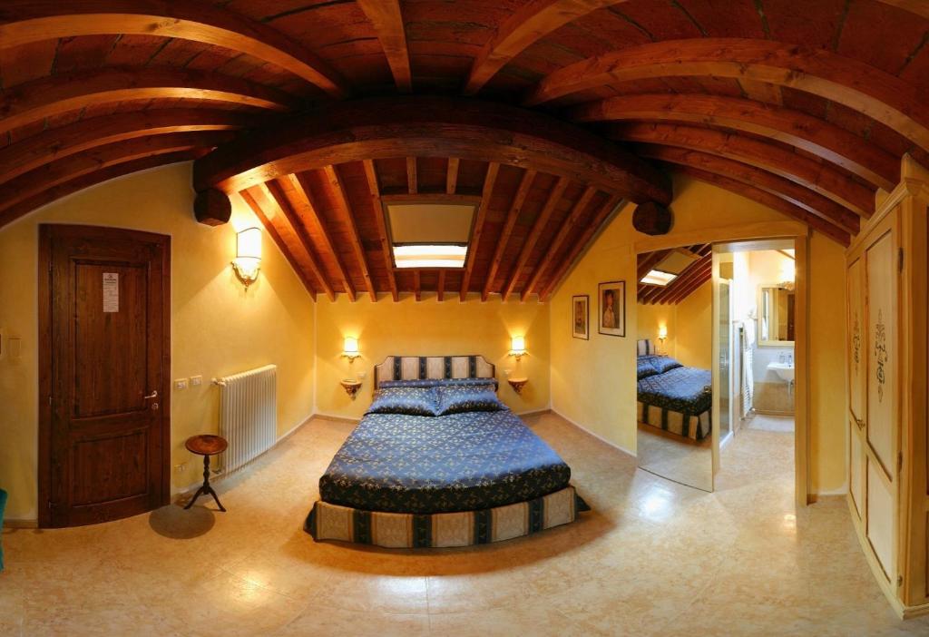a bedroom with a large bed with a wooden ceiling at Locanda Modigliani in Ferrara
