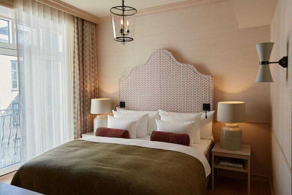 a bedroom with a large bed and a window at Henriks Hotel in Copenhagen