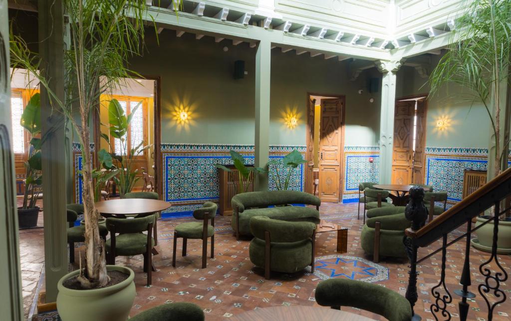 a lobby with chairs and a table in a building at Hotel Casa de la Torrecilla in Campo de Criptana