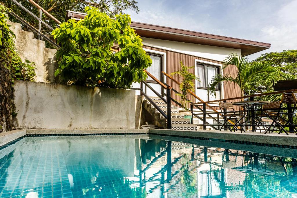 a swimming pool in front of a house at Uno Maya by Araw Residences in Nasugbu