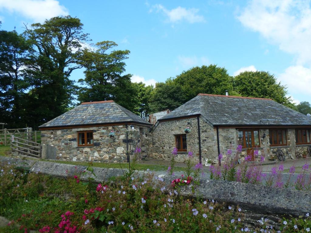 a stone house with flowers in front of it at The Old Wagon House in Saint Clether