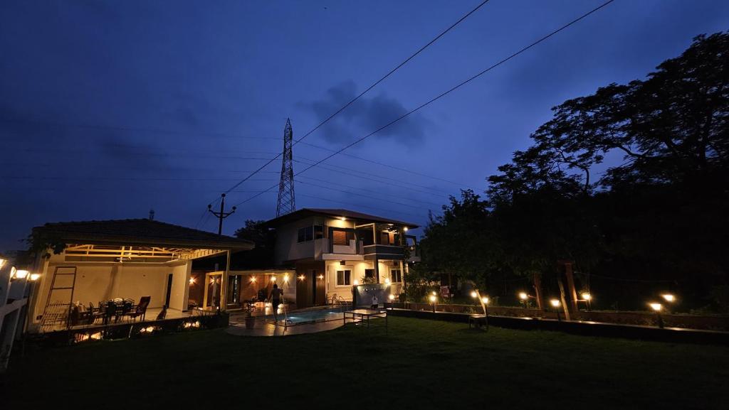 a house with lights in the yard at night at Mahak'sVilla in Indore