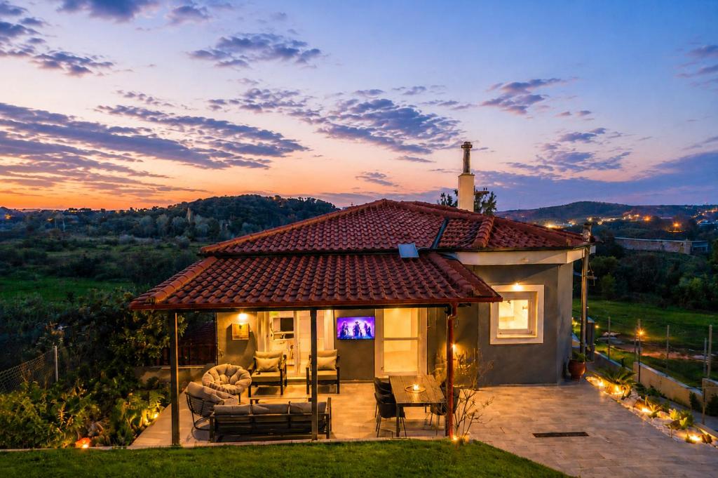 a small house with a patio and a sunset at Sountou home in Xanthi