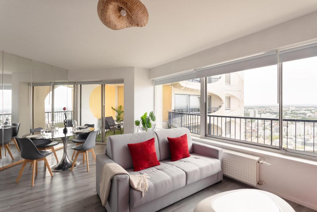 a living room with a white couch with red pillows at L'Horizon by Cocoonr in Rennes