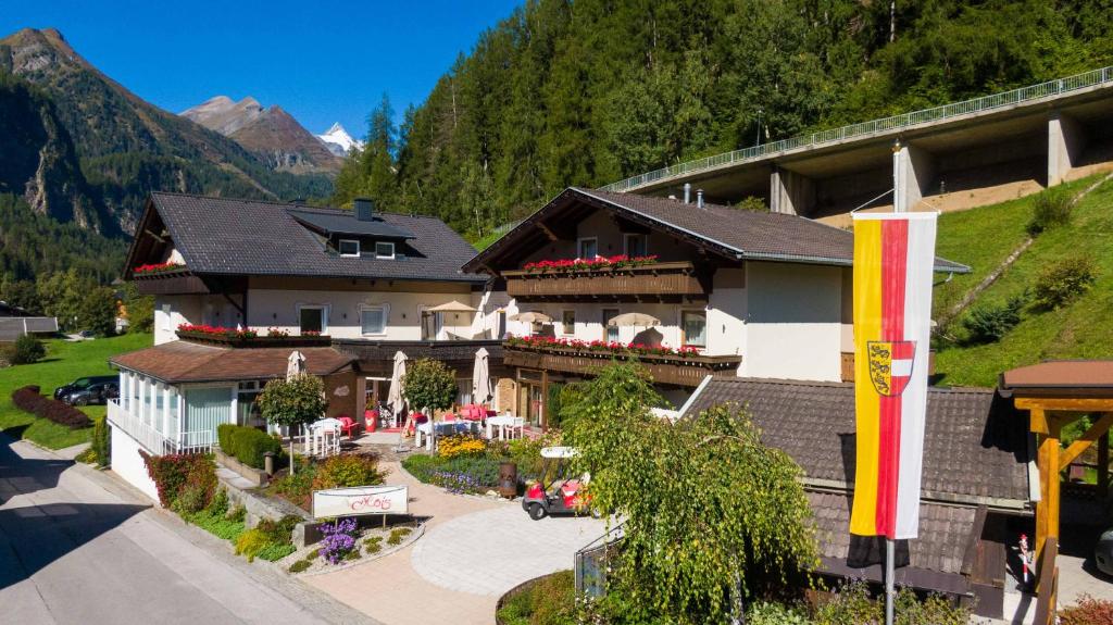 a building with a restaurant with a mountain in the background at Berghotel Hois in Heiligenblut
