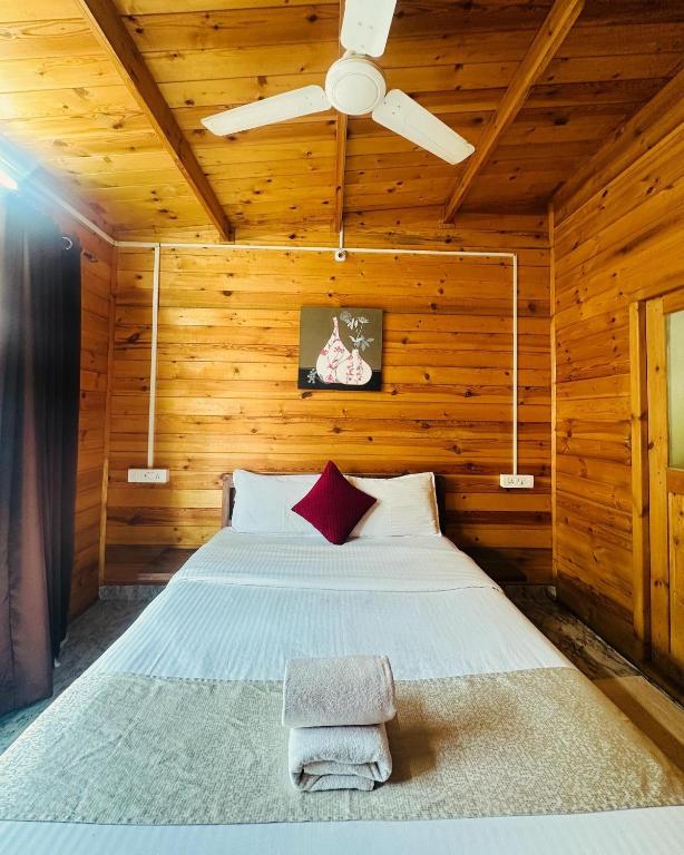 a bedroom with a bed in a wooden room at Hotel Inn morjim in Morjim