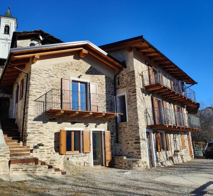 a stone house with a balcony on the side of it at Alloggio Bellavista in Rore
