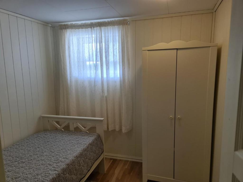 a bedroom with a bed and a dresser and a window at Søvikhus in Haram