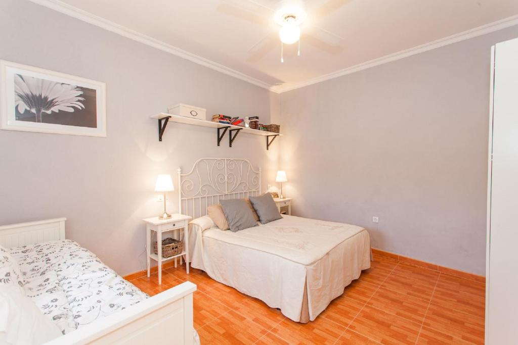 una camera bianca con letto e tavolo di Apartamento Centro Jerez Carbón a Jerez de la Frontera