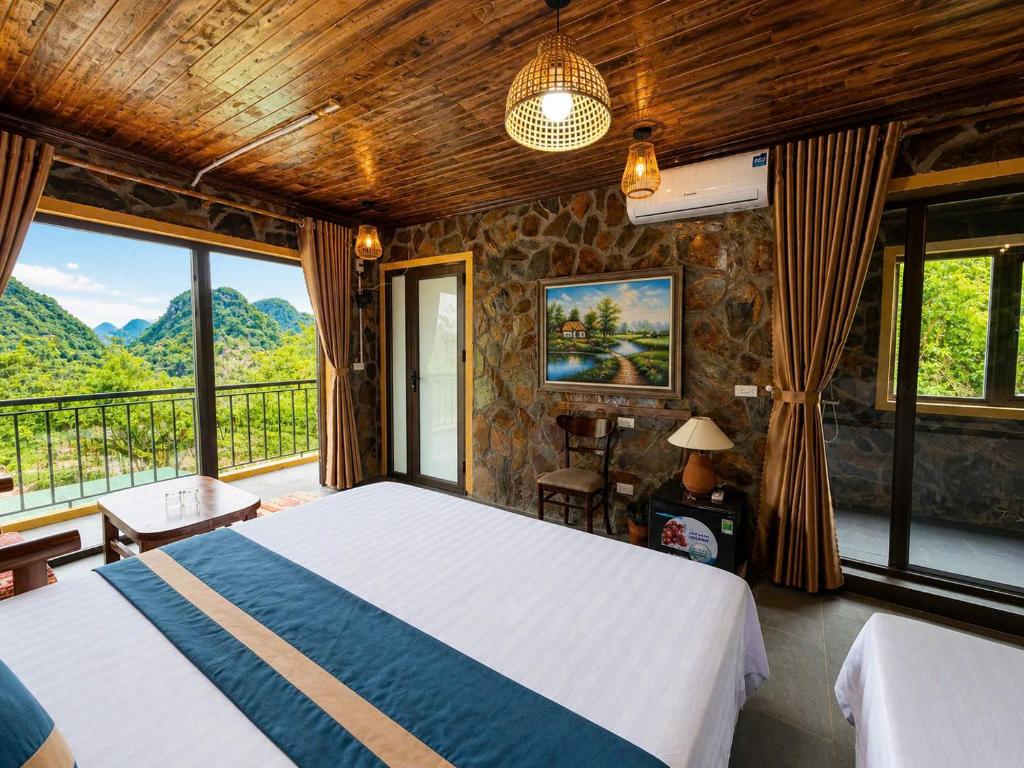 a bedroom with a bed in a room with windows at Tam Coc Mountain Ecolodge in Ninh Binh