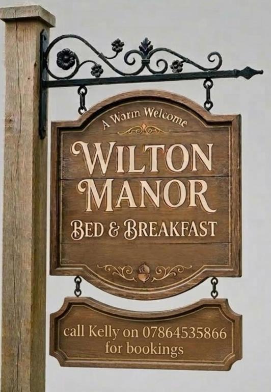 a sign for a williton manor bed and breakfast at Wilton Manor 79 Wilton road in Feltwell