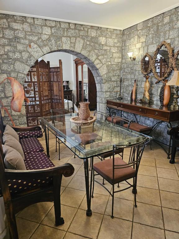 a table and chairs in a room with a stone wall at Amfitrion Apartments in Gythio