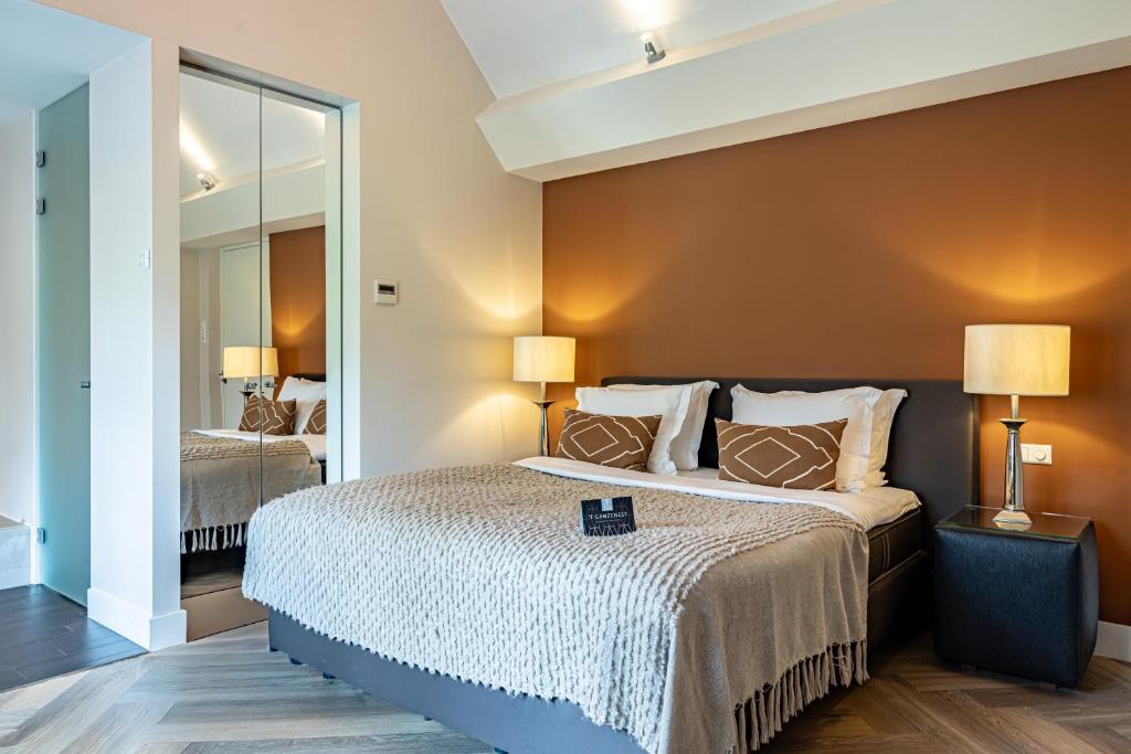 a bedroom with a large bed and a mirror at 't Ganzenest Restaurant # klein hotel in Rijswijk