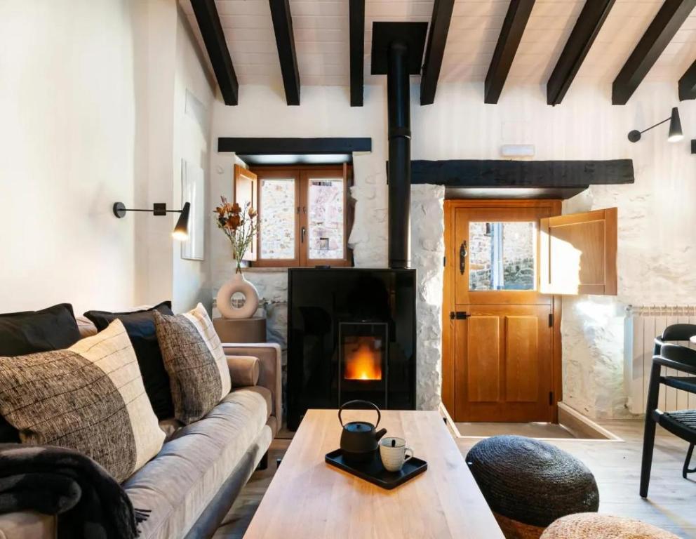 a living room with a couch and a fireplace at El Nido Rural Boutique Villa in La Focella