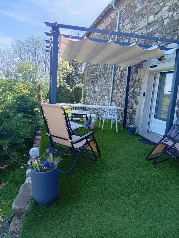 a patio with a table and chairs under an umbrella at Mini gite 1à4 personnes Studio 7 in Gelles