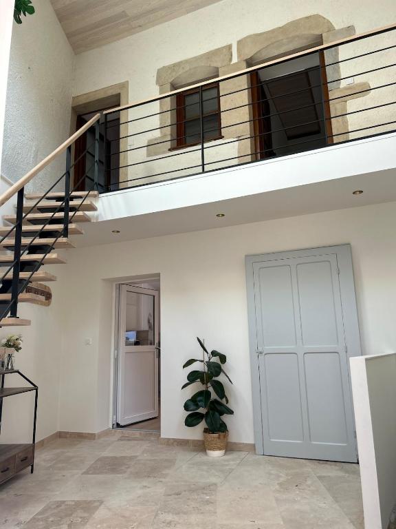 a staircase in a house with a door and a plant at Escale Pesmoise in Pesmes