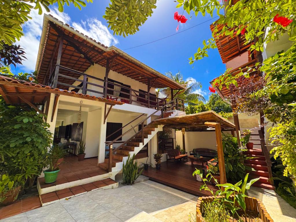 a house with a porch and a patio at Pousada Casa da Edinha in Ilha de Boipeba