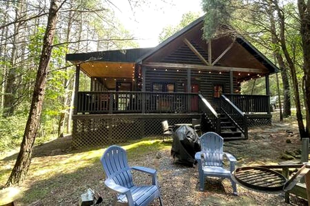 a cabin with two blue chairs and a house at Cedar Gap Hideaway in Indiana in Birdseye