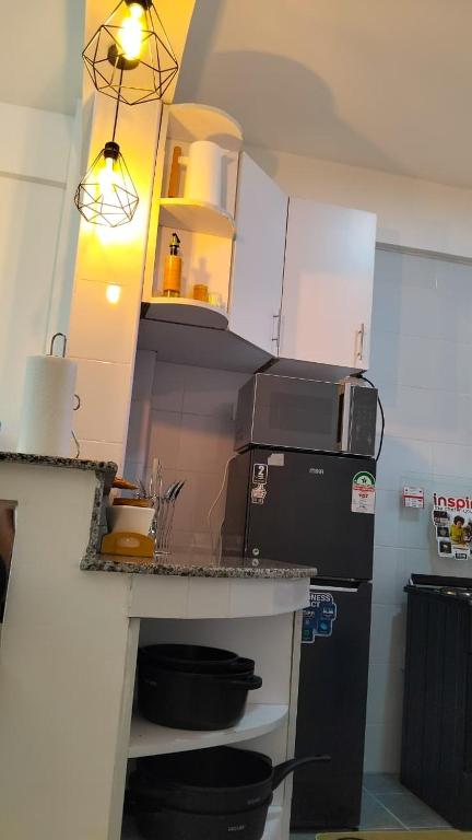 a kitchen with a refrigerator and a counter with a microwave at Vito Haven suites in Busia