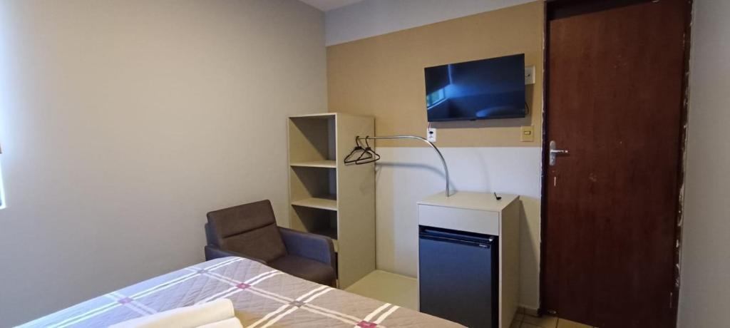 a bedroom with a bed and a lamp and a tv at Escuna Praia Hotel in João Pessoa